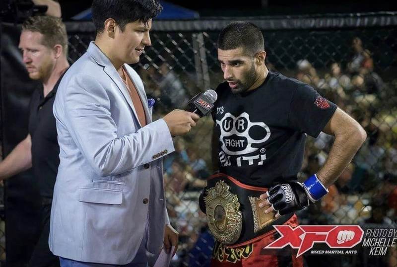 Feroz Khan wearing his championship belt during a cage-side interview